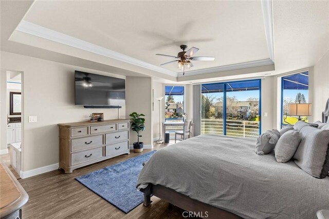 bedroom featuring wood finished floors, access to outside, a raised ceiling, baseboards, and ornamental molding