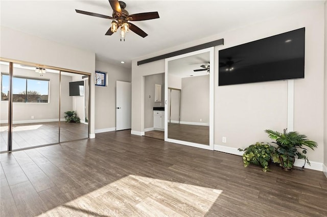 unfurnished living room with wood finished floors, a ceiling fan, and baseboards