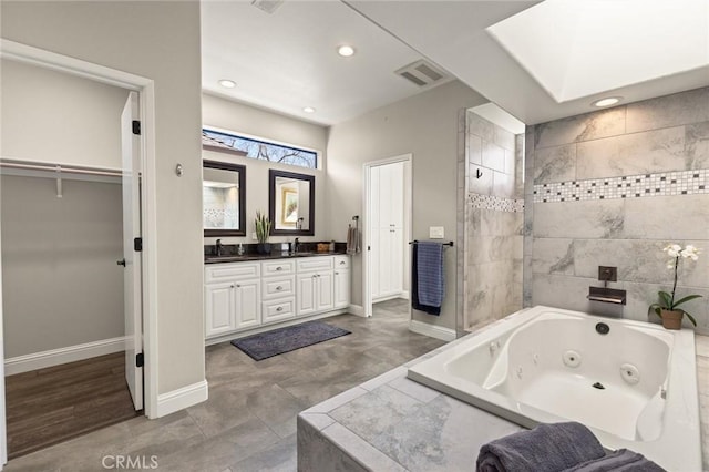 bathroom with baseboards, visible vents, a whirlpool tub, and double vanity