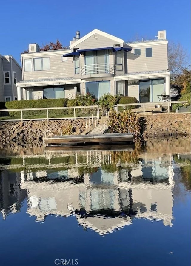 back of property featuring a water view and a balcony