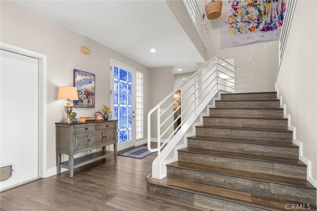 stairs with recessed lighting, wood finished floors, and baseboards