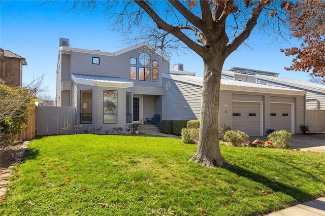 view of front of property featuring driveway, an attached garage, fence, and a front yard