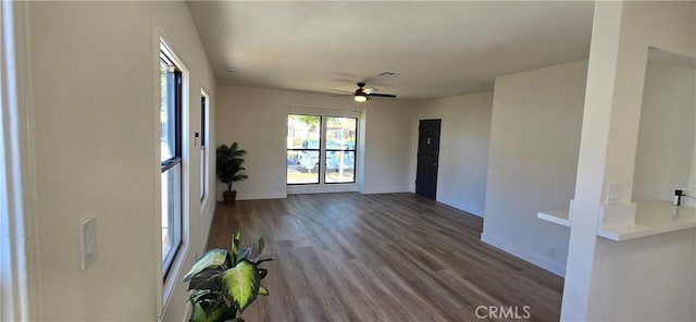 interior space with ceiling fan, baseboards, and wood finished floors