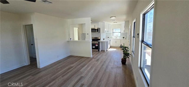 interior space featuring dark wood-style floors, visible vents, and baseboards