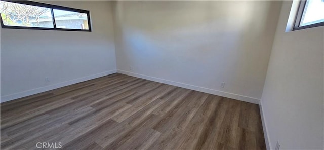 empty room featuring baseboards and wood finished floors