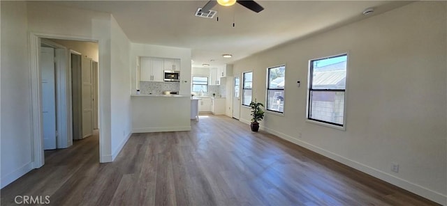 interior space featuring dark wood-style floors, baseboards, visible vents, and a ceiling fan