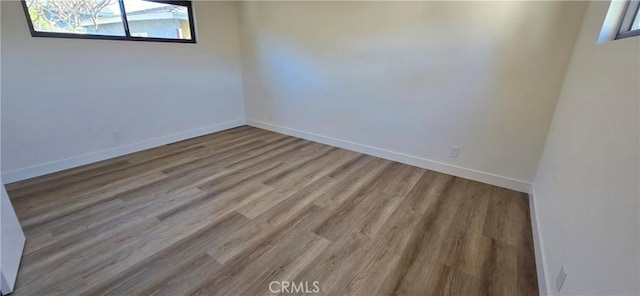 empty room featuring baseboards and wood finished floors