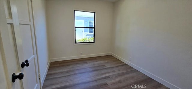 unfurnished bedroom featuring baseboards and dark wood finished floors