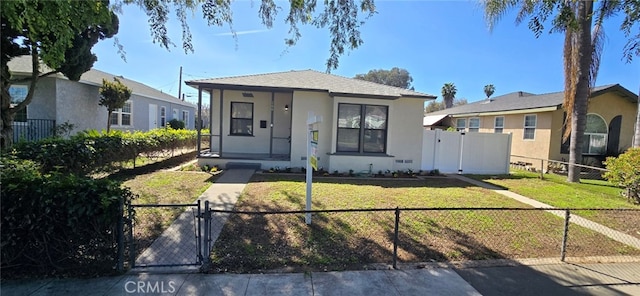 bungalow with a front lawn, a fenced front yard, a gate, and stucco siding