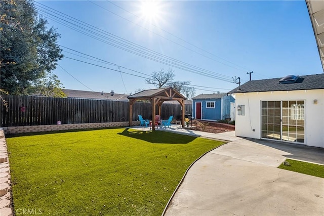 view of yard with an outbuilding, a fenced backyard, a patio, and a gazebo