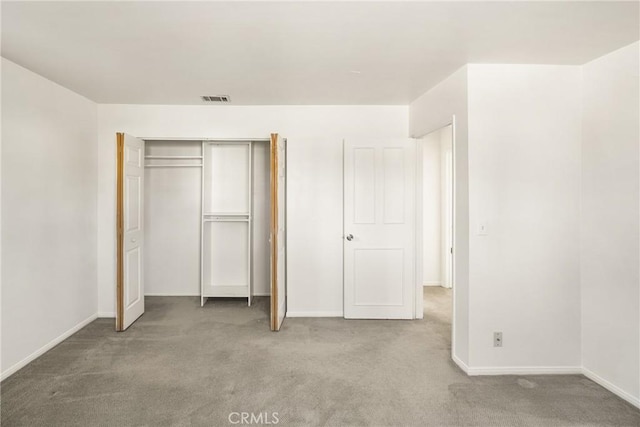 unfurnished bedroom with carpet floors, baseboards, visible vents, and a closet