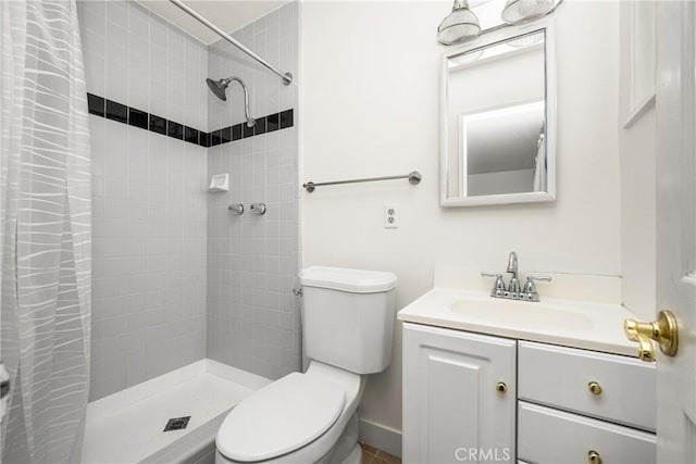 full bath featuring a tile shower, vanity, and toilet