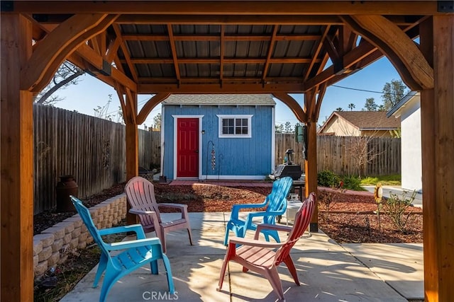 view of patio with an outbuilding, a gazebo, a storage unit, and a fenced backyard