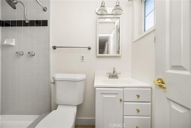 bathroom with vanity, a tile shower, and toilet