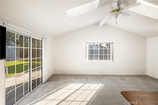 interior space with a ceiling fan and vaulted ceiling with skylight