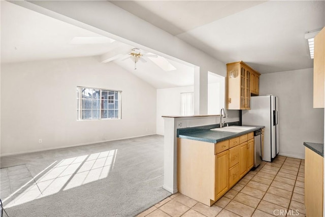 kitchen with light colored carpet, a ceiling fan, open floor plan, a sink, and dishwasher