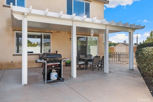 view of patio / terrace featuring a grill, fence, and outdoor dining space