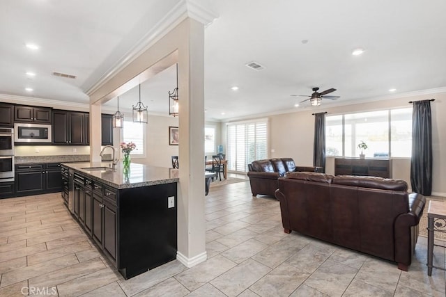 kitchen with stainless steel appliances, visible vents, a sink, and ornamental molding