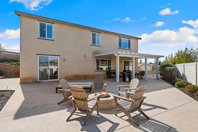 rear view of house featuring an outdoor fire pit, a fenced backyard, a patio area, a pergola, and stucco siding