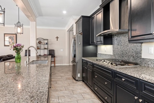 kitchen with dark cabinets, a sink, ornamental molding, appliances with stainless steel finishes, and wall chimney exhaust hood