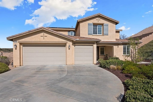 view of front facade with concrete driveway, an attached garage, a tile roof, and stucco siding