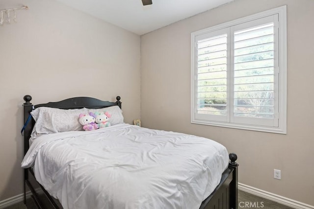 bedroom with ceiling fan and baseboards