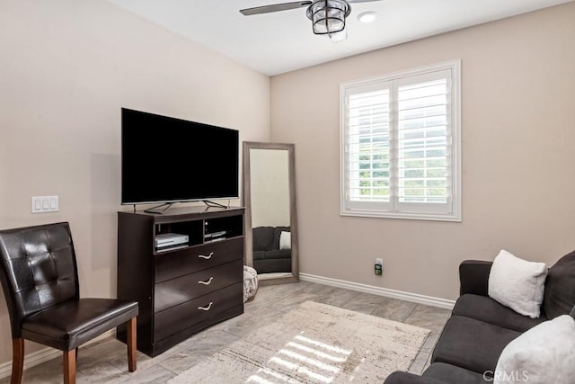 living room featuring a ceiling fan and baseboards