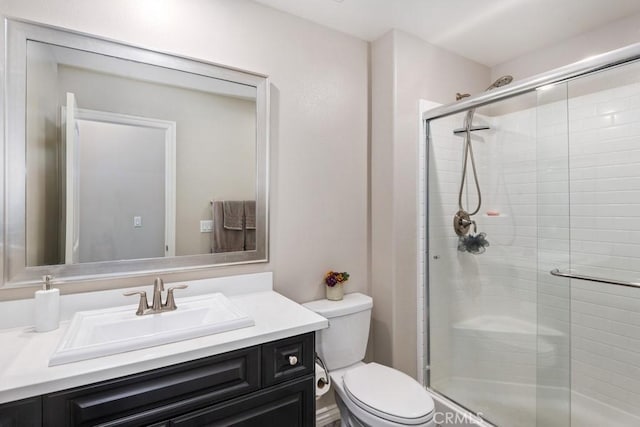 full bathroom featuring a shower stall, toilet, and vanity