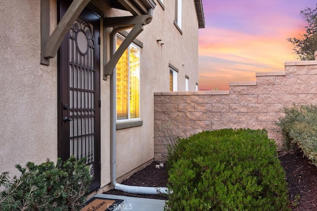 view of exterior entry featuring stucco siding