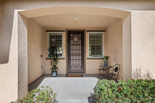 entrance to property featuring stucco siding