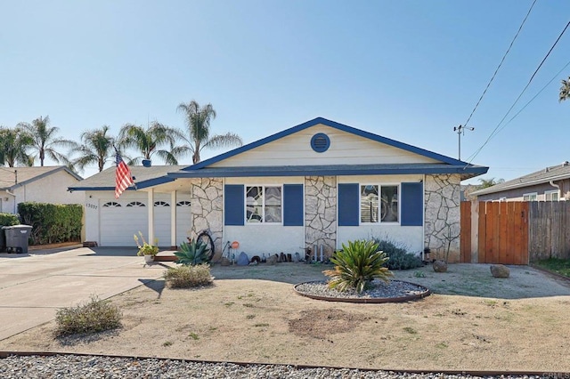 single story home featuring a garage, concrete driveway, stone siding, and fence