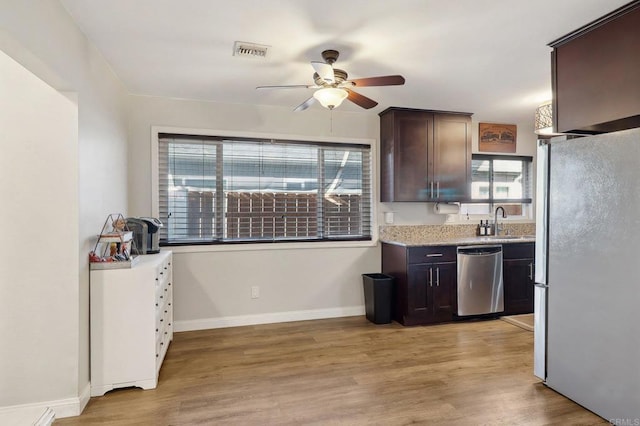 kitchen featuring light wood finished floors, visible vents, appliances with stainless steel finishes, a healthy amount of sunlight, and dark brown cabinets