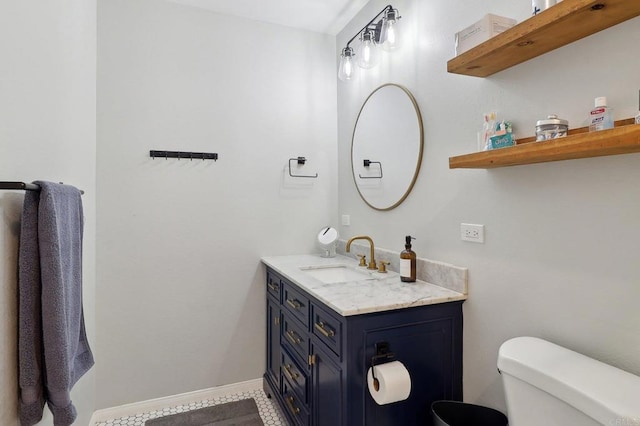 bathroom featuring baseboards, vanity, and toilet