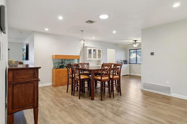 dining area with light wood-type flooring, visible vents, and recessed lighting