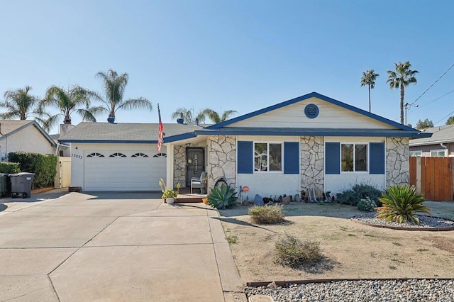 ranch-style house featuring stone siding, concrete driveway, fence, and an attached garage