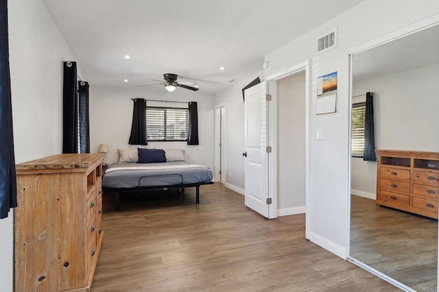 bedroom featuring recessed lighting, wood finished floors, a ceiling fan, visible vents, and baseboards