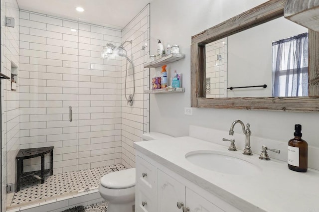 bathroom with toilet, a shower stall, and vanity