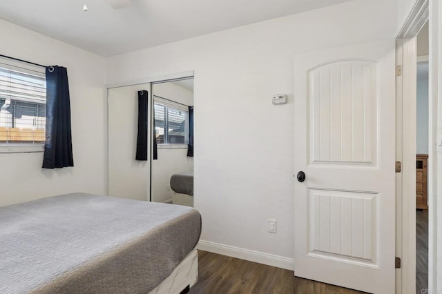 bedroom featuring a closet, baseboards, and dark wood-style flooring