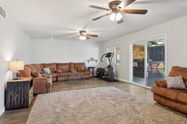 living room with a ceiling fan, wood finished floors, visible vents, and baseboards