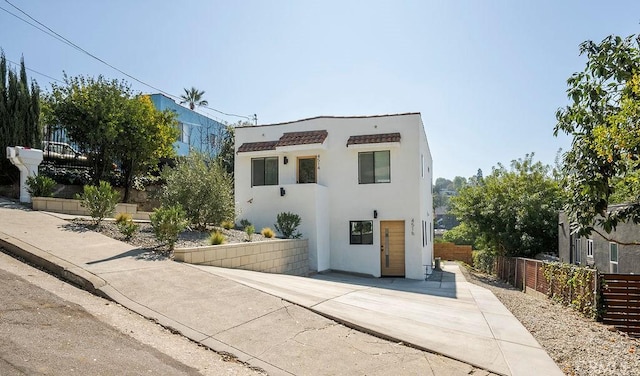 contemporary house featuring fence, a patio, and stucco siding