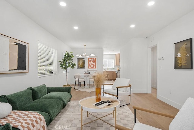 living room featuring recessed lighting, baseboards, and light wood finished floors