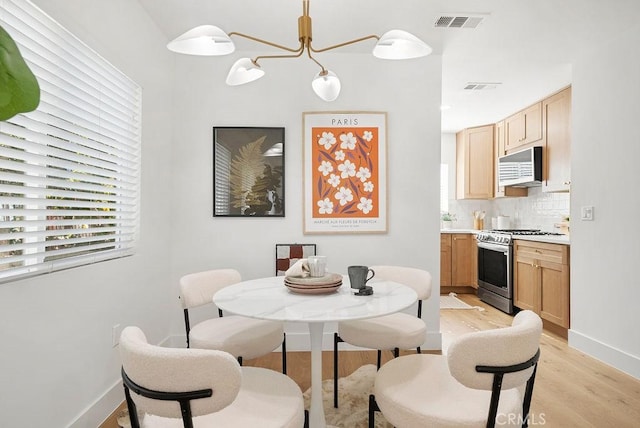 dining room with plenty of natural light, visible vents, and light wood-style floors