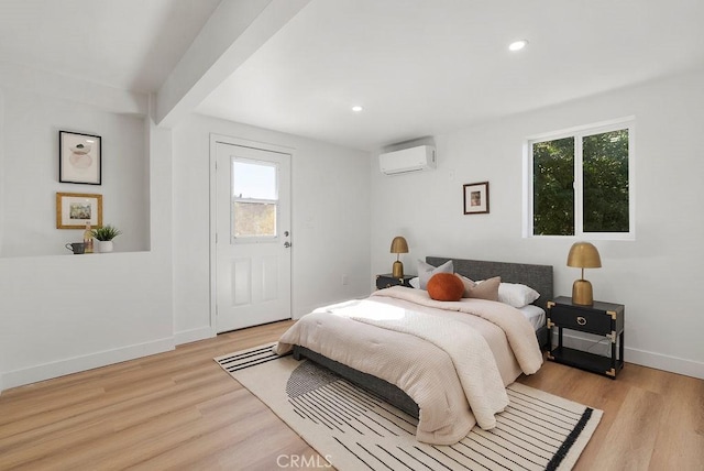 bedroom featuring light wood-style floors, baseboards, an AC wall unit, and recessed lighting