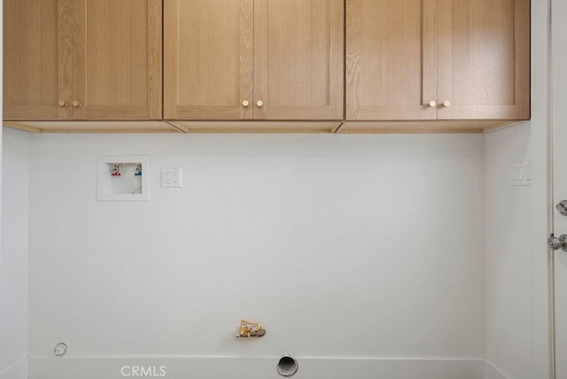 clothes washing area featuring washer hookup and cabinet space