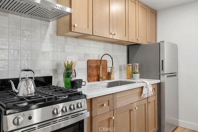 kitchen featuring extractor fan, stainless steel appliances, a sink, light countertops, and tasteful backsplash