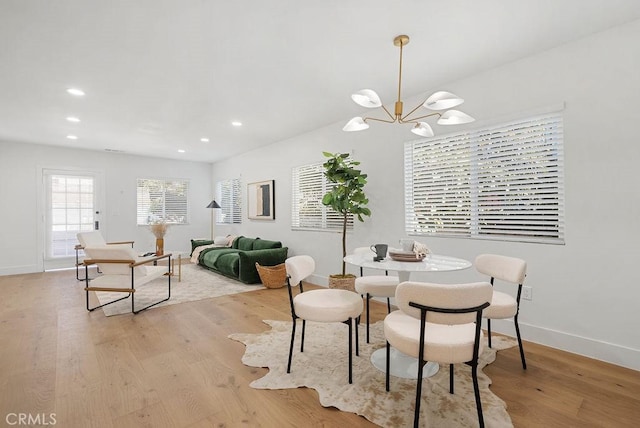 dining area featuring light wood-style floors, recessed lighting, a notable chandelier, and baseboards