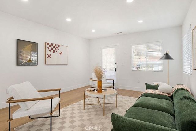 living room featuring baseboards, light wood-type flooring, visible vents, and recessed lighting