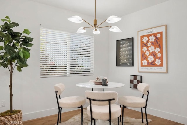 dining area with a notable chandelier, baseboards, and wood finished floors