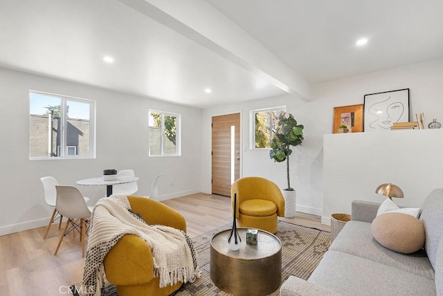 living area with beamed ceiling, light wood-type flooring, and baseboards