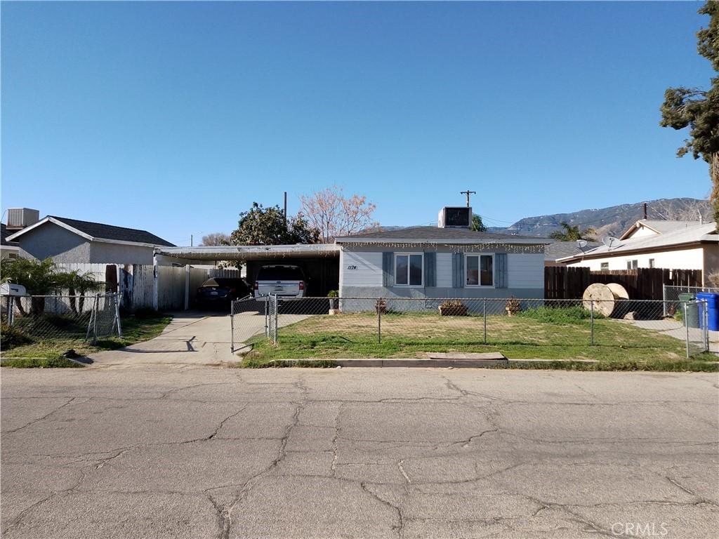 view of front of home with concrete driveway, a fenced front yard, cooling unit, a front lawn, and a carport